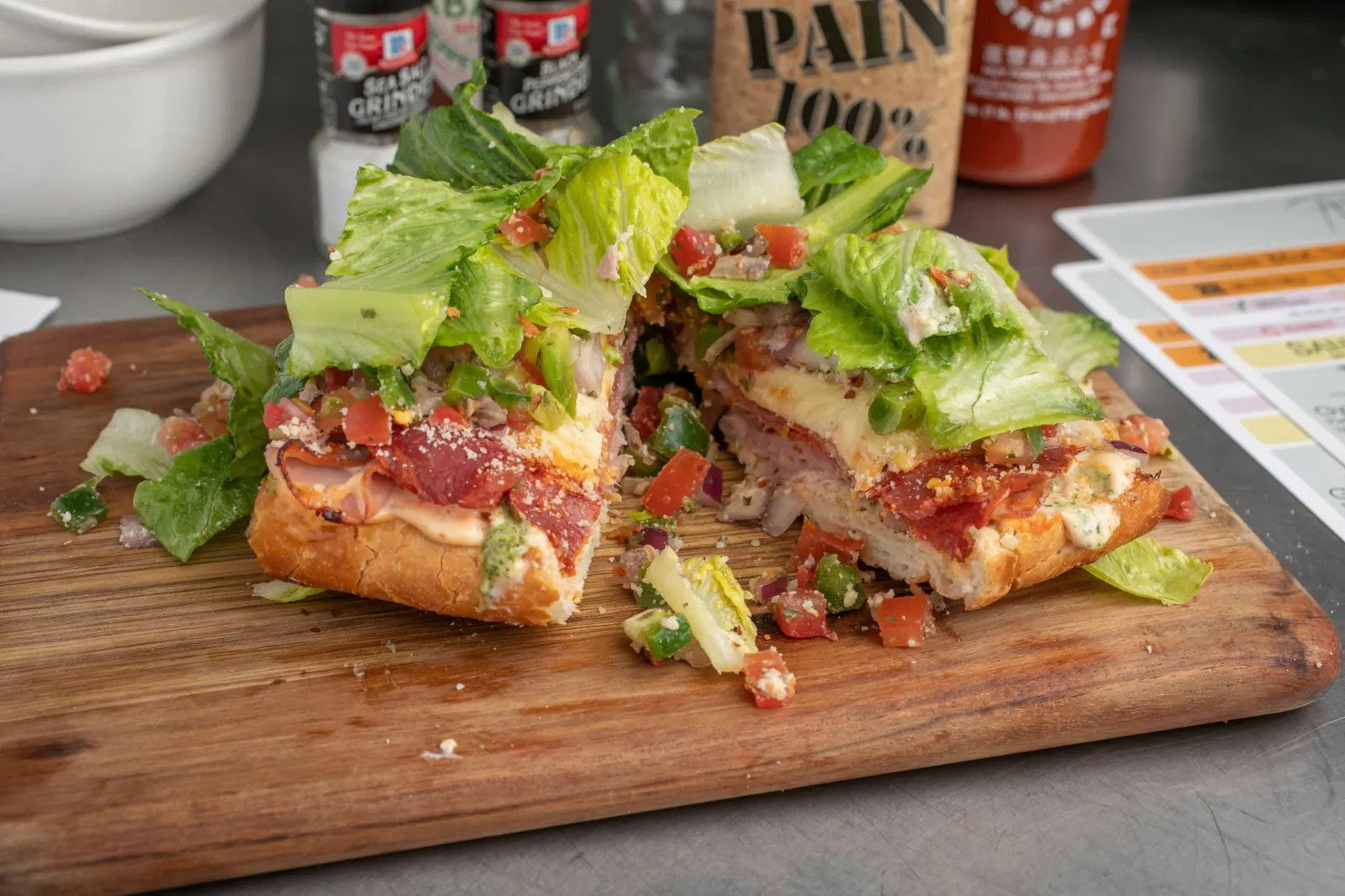 Calyn’s Donkey sandwich on a cutting board, stacked with salami, pepperoni, capicola, ham and romaine